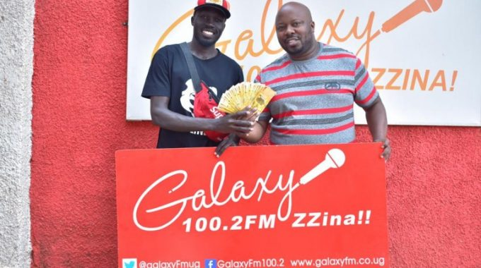 DJ Nomrod handing over cash to past participants in the dance challenge.